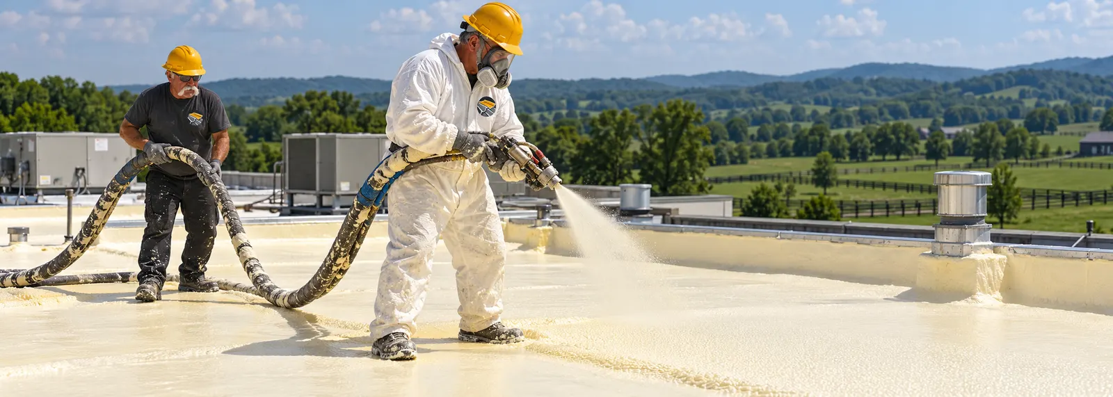 Roofer spraying foam over a metal roof on a commercial building